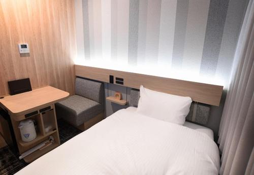 东京上野广小路R＆B酒店的小房间设有一张床和一张书桌