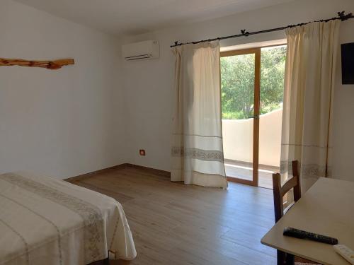 阿尔扎凯纳Turismo Rurale Lu Stazzu Arzachena的一间卧室设有一张床和一个大窗户