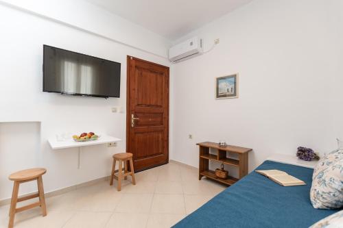 纳克索乔拉Amaranto Naxos 2的卧室配有一张床,墙上配有电视。