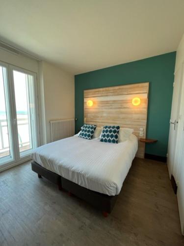 圣马洛Alba hotel的一间卧室配有一张带两个枕头的床