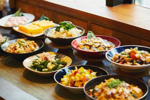 东京hotel MONday Tokyo Nishikasai的桌子上放着各种食物的碗