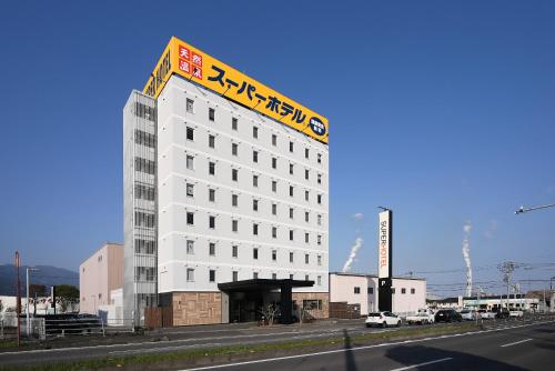 四国中央市Super Hotel Shikoku-chuo的白色的建筑,上面有标志