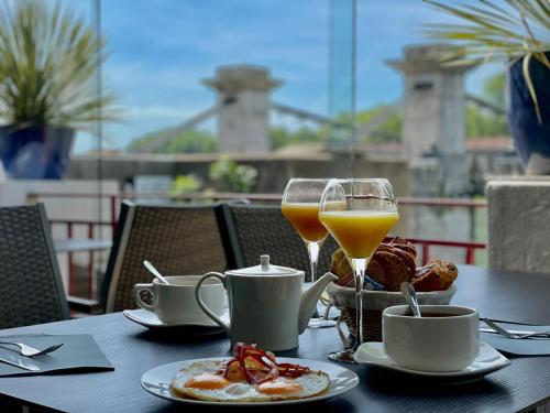 坦耶尔米塔格Hôtel Les Deux Coteaux的一张桌子,上面有早餐食品和两杯橙汁