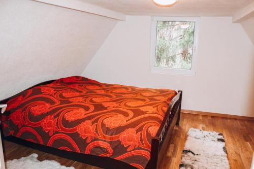 KakanjVilla Katharina的一间卧室配有一张带红色和橙色毯子的床