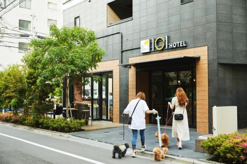 东京ICI HOTEL Asakusabashi的两个女人在商店前走狗