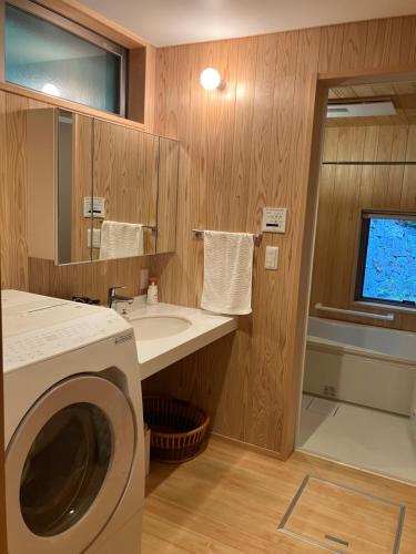 AkaiwaCasa KitsuneAna The Satoyama experience in a Japanese-style modernized 100-year-old farmhouse的一间带洗衣机和水槽的浴室