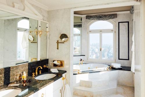 卢塞恩古奇城堡酒店的浴室配有2个盥洗盆和1个浴缸。