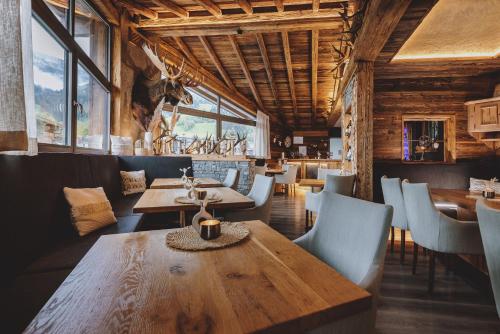 卡普伦Margarethenstein Boutique Hotel的餐厅设有木桌、椅子和窗户。