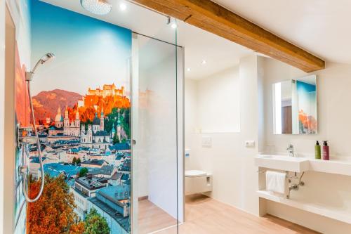 萨尔茨堡罗森维拉酒店的浴室设有淋浴,墙上挂有城市画作