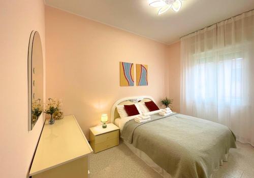 佩斯基耶拉德加达Appartamento 2, Villa Magnolia, 64mq, Lago di Garda的一间卧室配有一张床、一个梳妆台和一扇窗户。