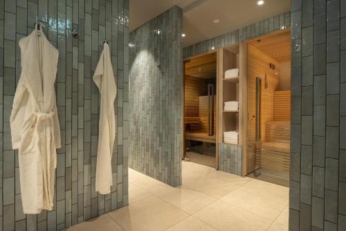 慕尼黑玛丽蒂姆慕尼黑酒店的浴室设有灰色的瓷砖墙壁和步入式淋浴间。