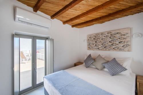 帕罗斯岛Rina Houses的一间卧室设有一张床和一个大窗户