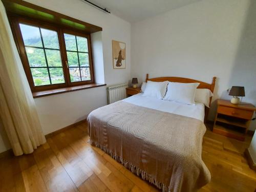 维耶拉VIelha V的一间卧室设有一张大床和一个窗户。
