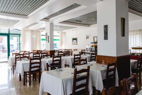 法蒂玛Hotel Santo António de Fátima的一间设有白色桌椅的用餐室