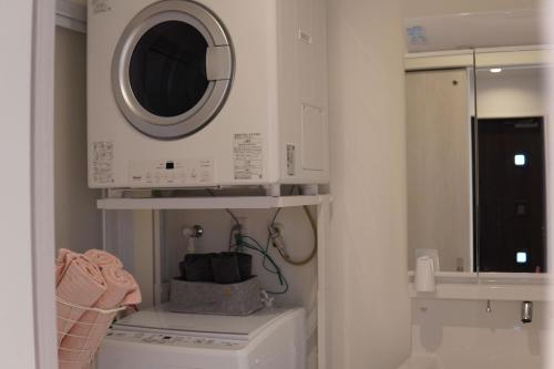宫古岛きくのこ3缶ヴィラ＆テラス　的洗衣房配有洗衣机和微波炉