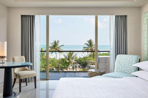 库塔Sheraton Bali Kuta Resort的一间卧室配有一张床,享有海景