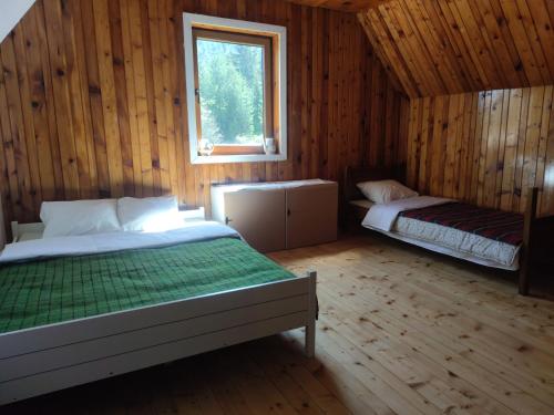 扎布利亚克Vukov Konak - Wolf's lodge的小木屋内一间卧室,配有两张床