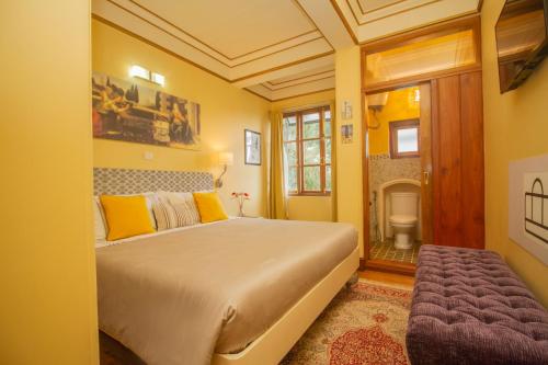 甘托克Amritara 5 BHK Luxury Villa, Gangtok的一间卧室设有一张黄色墙壁的大床