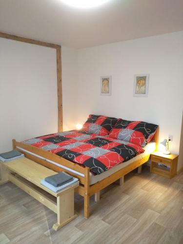 KněževesHrnčírna的一间卧室配有一张带红色和黑色棉被的床