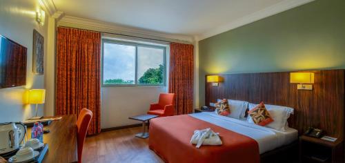 阿克拉Alisa Hotel North Ridge的酒店的客房 - 带一张床、椅子和窗户
