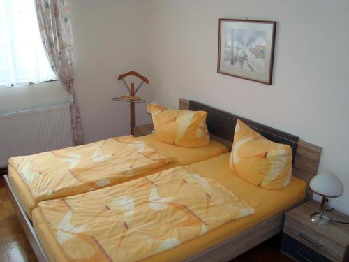 策勒Wachholz, Ferienwohnung的一间卧室配有两张带黄床单的床