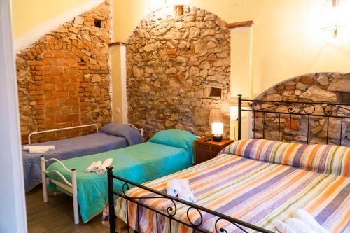 坎丕里亚麦利蒂玛Affitta Camere Lido&Lida的一间卧室设有两张床和石墙