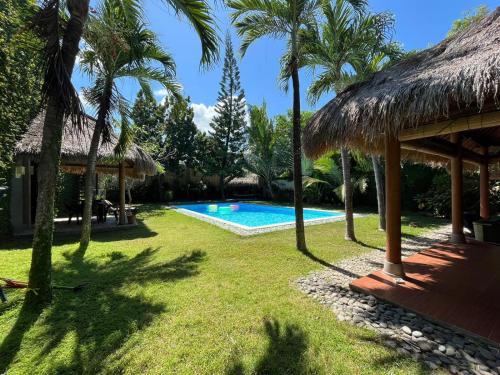 库塔KUTA - 4BR Villa with Private XL Pool的一个带游泳池和棕榈树的度假村