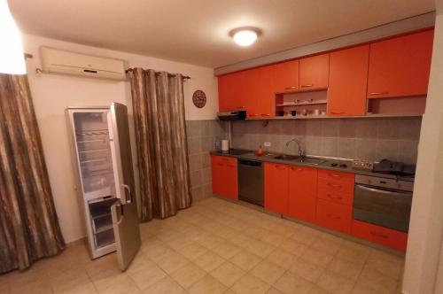 布德瓦The rising sun的厨房配有橙色橱柜和冰箱