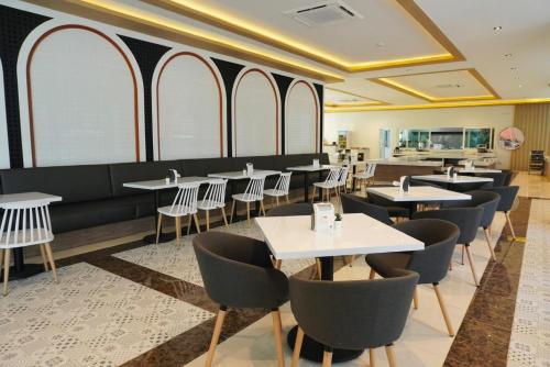 农布M CASA HOTEL PATTAYA的用餐室设有桌椅和窗户。
