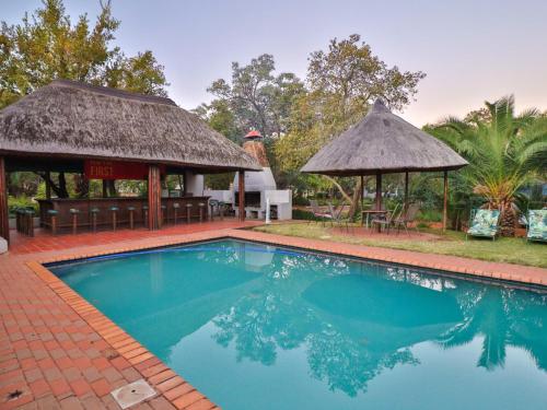 贝拉贝拉Thuto Centre Conferencing & Bush Lodge的一个带凉亭的游泳池和一个度假村