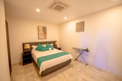 南迪El Palm的一间卧室配有一张带绿色枕头的床
