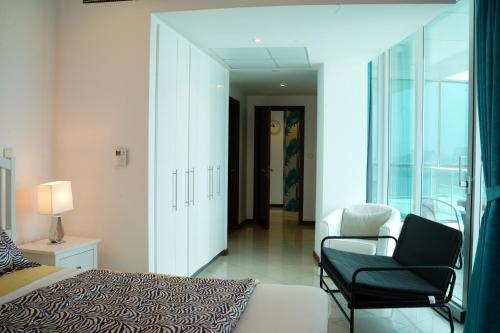 迪拜Luxurious Penthouses的卧室配有床、椅子和窗户。