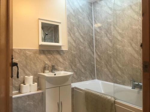 曼海德Recently renovated 3-Bed Apartment on Exmoor的浴室配有水槽、淋浴和浴缸。