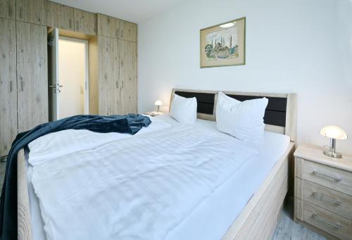 耐德西茨Ferienwohnung Hogwarts的卧室配有一张白色大床和木制床头板