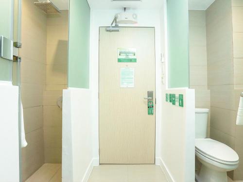 马尼拉Go Hotels North EDSA的一间带卫生间和门的浴室