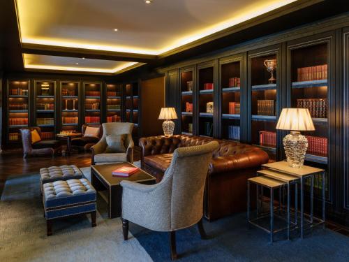 基拉尼欧罗巴假日酒店的一个带棕色皮沙发和椅子的图书馆