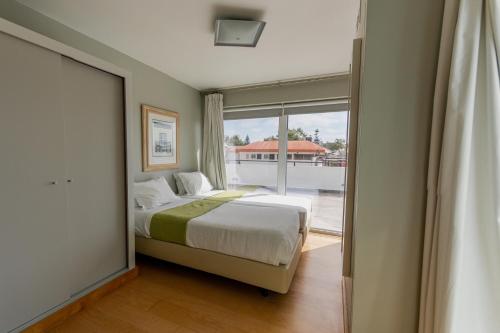 卡斯卡伊斯卡斯卡伊斯酒店 的一间卧室设有一张床和一个大窗户
