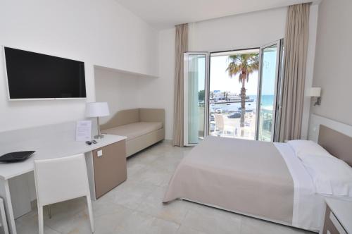 切萨雷奥港Onda B&B的酒店客房配有一张床、一张书桌和一台电视。