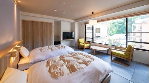 上田市中松屋传统日式旅馆的酒店客房设有两张床和电视。