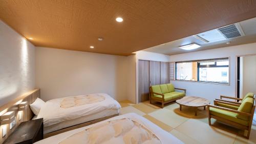 上田市中松屋传统日式旅馆的一间卧室配有一张床、一把椅子和一张桌子