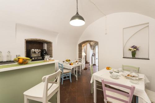 塔尔奎尼亚B&B I Tre Camini的厨房以及带白色桌椅的用餐室。