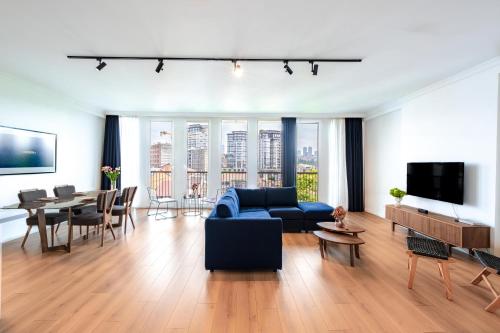 伊斯坦布尔Homie Suites - Luxury Apartments in Maçka的客厅配有蓝色的沙发和桌子