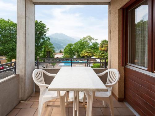 MassagnoApartment Resort al Centro-1 by Interhome的美景阳台配有白色的桌椅