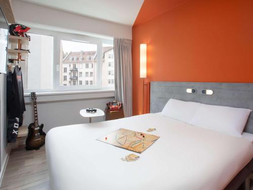 斯特拉斯堡ibis budget Strasbourg Centre Republique的一间卧室配有一张白色的床和橙色的墙壁