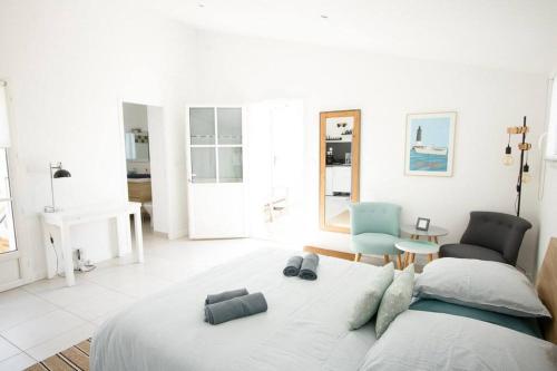 雷岛圣玛丽Maison 3 chambres plus 1 studio indépendant的白色卧室配有床和椅子