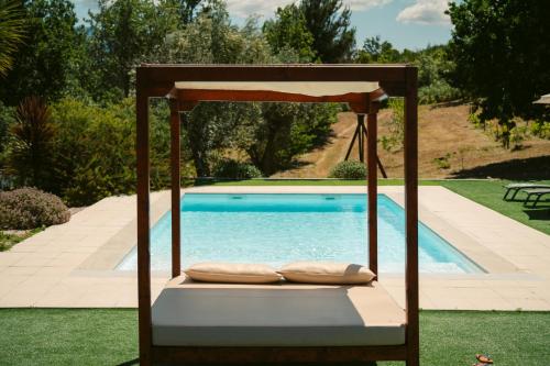 奥利维拉多霍斯比托Pura - Home in Nature的游泳池旁的摆动床和枕头