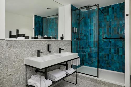 沃特福德沃特福德码头酒店的一间带水槽和玻璃淋浴的浴室