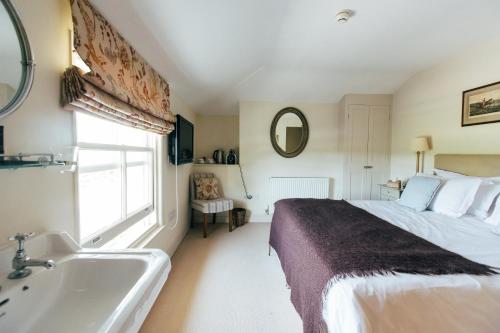 利明顿东臂酒店的一间卧室配有一张床、一个浴缸和一个水槽