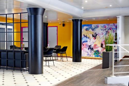 哥本哈根斯堪的纳维亚卡宾酒店的大厅里设有黑色柱子和色彩缤纷的墙壁