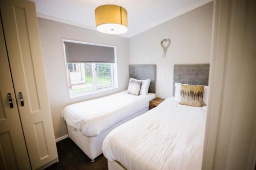 布莱克浦Ream Hills Holiday Park的小型客房 - 带2张床和窗户